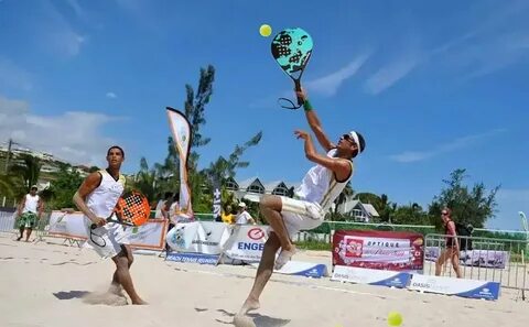 Jogador de beach tennis realizando passos de ajuste na quadra de areia.