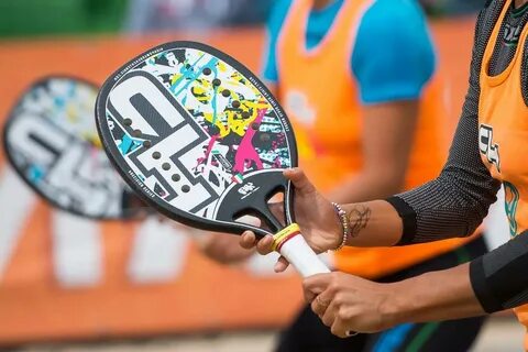 Jogador de beach tennis treinando tempo de reação e movimentação em quadra de areia.