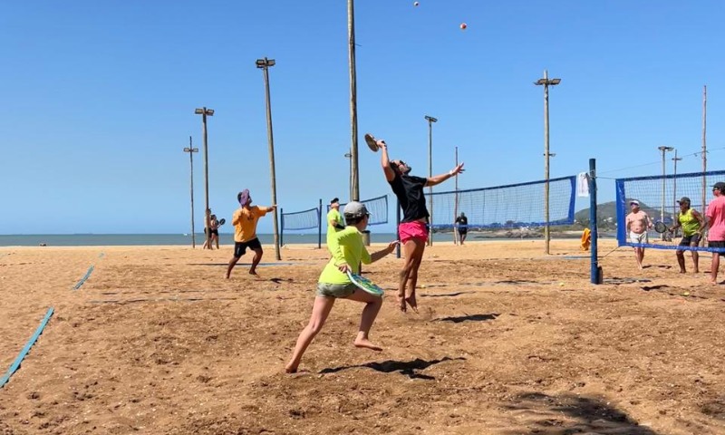 Atletas competindo no Tribuna Open de Beach Tennis na praia de Camburi.