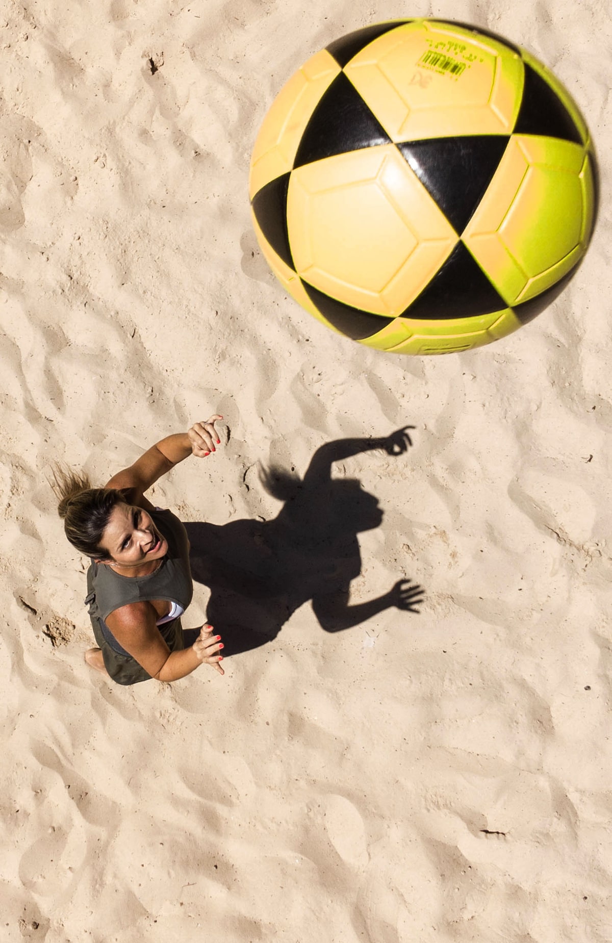 Praticantes de beach tennis e futevôlei em quadras de areia em São Paulo.