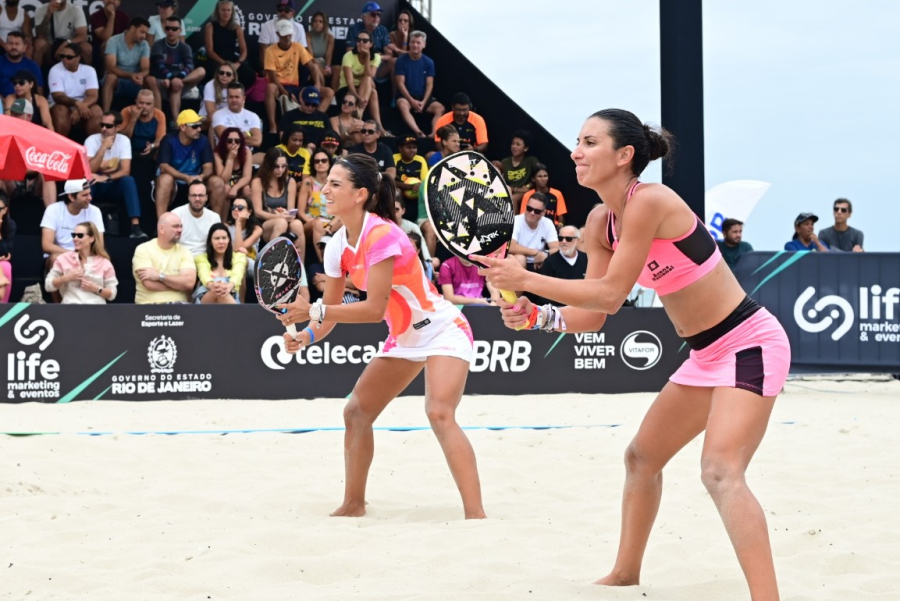 Atletas competindo no evento de beach tennis em Copacabana, destacando a beleza da praia e a energia do esporte.