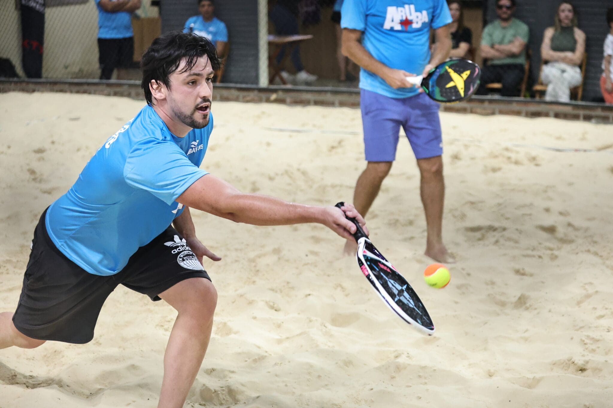 Atletas competindo no 1º torneio de Beach Tennis do Festuris em Gramado, celebrando o esporte e o turismo.