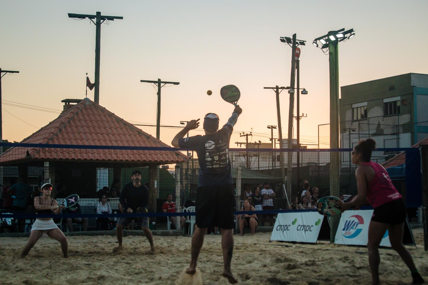 Atletas competindo no 3º Open de Beach Tennis do Sport Club Itapuí, mostrando a diversidade de participantes e categorias.