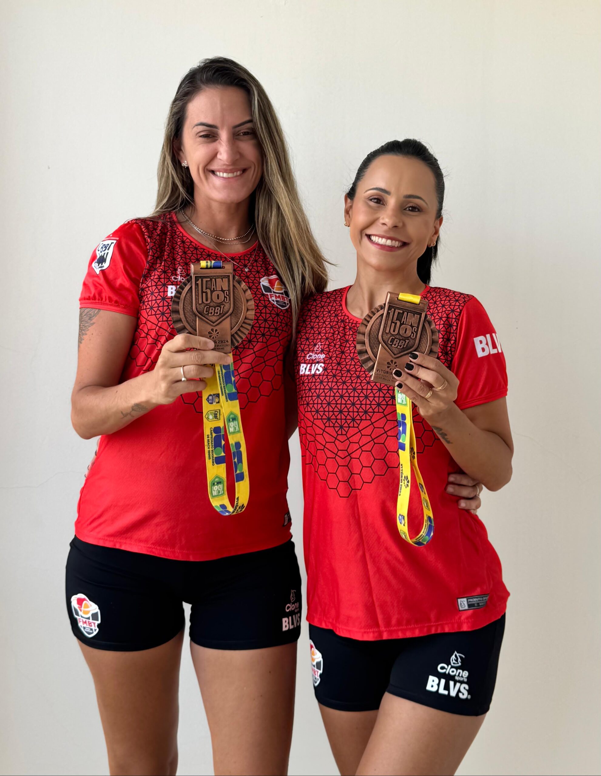 Fernanda Caroline e Laura Mendes segurando a medalha de bronze após o torneio de beach tennis em Vitória, Espírito Santo.