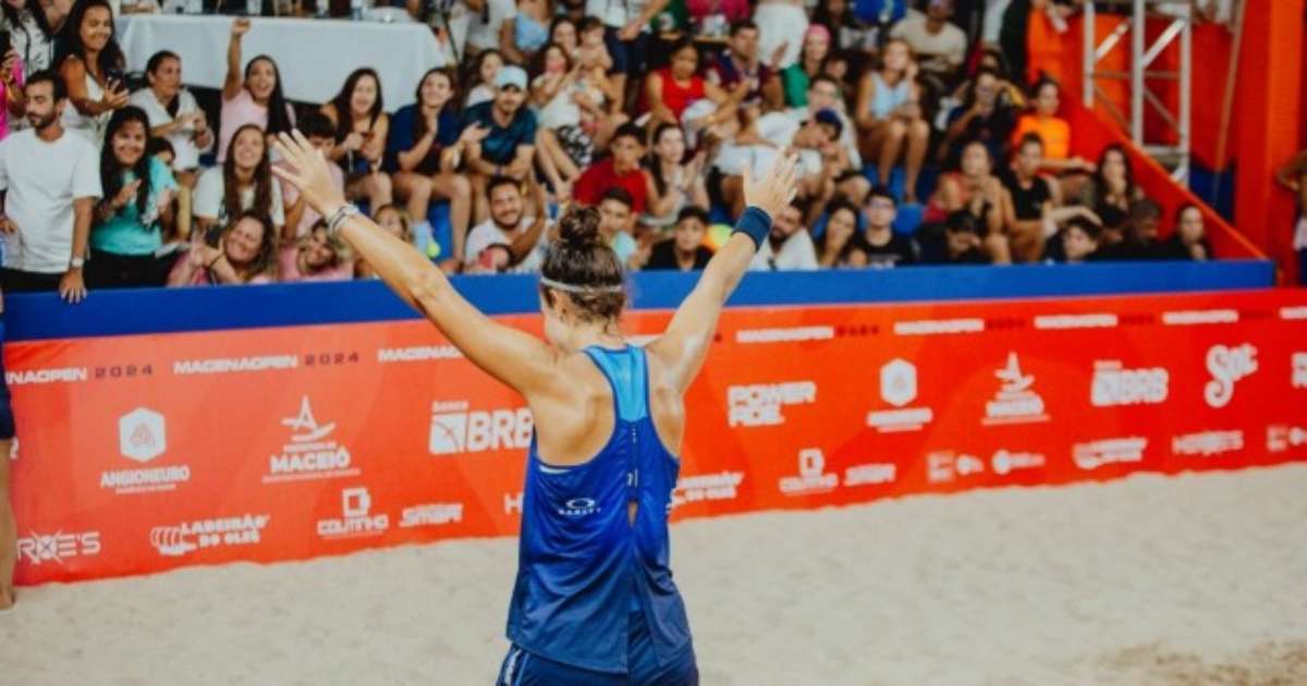 Atletas competindo no Macena Open de Beach Tennis em Maceió, com público vibrante ao fundo.