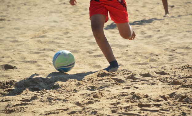 Atletas competindo em diversas modalidades esportivas na praia de Rio Pardo.