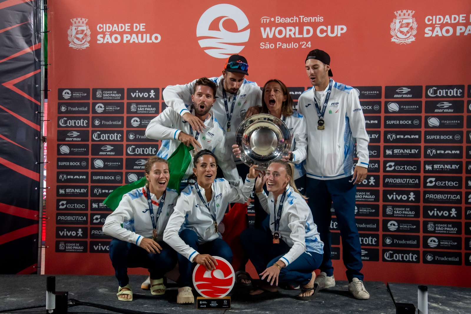 Jogadores de beach tennis competindo na Copa do Mundo, com destaque para a equipe brasileira e italiana.