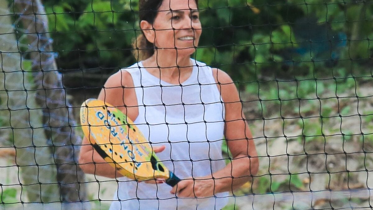 Miriam Macedo treinando beach tennis na praia da Barra da Tijuca, mostrando sua forma física e energia aos 60 anos.