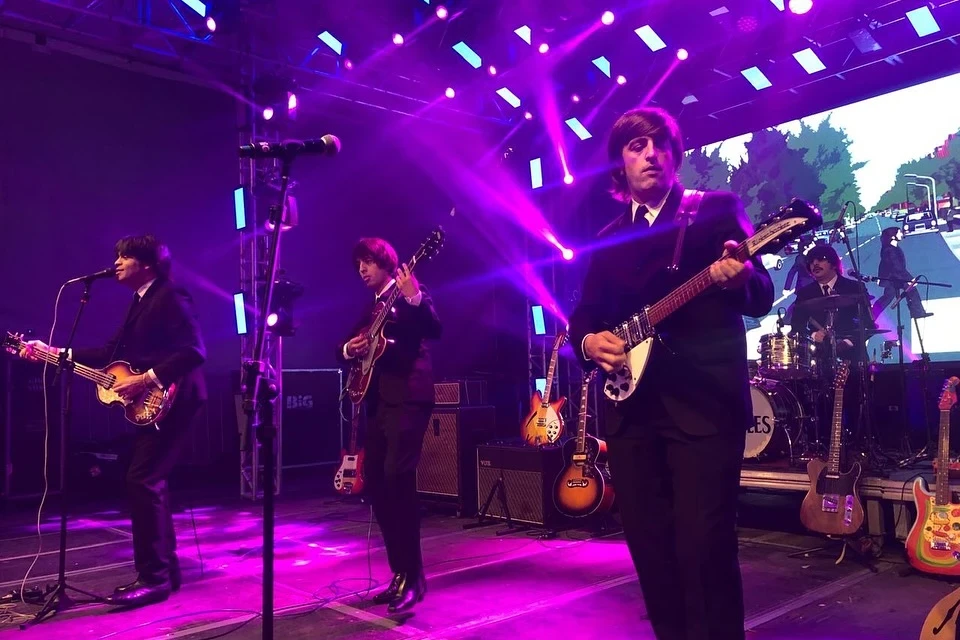 Banda The Beetles se apresentando ao vivo em Balneário Arroio do Silva, homenageando os Beatles com energia e emoção.