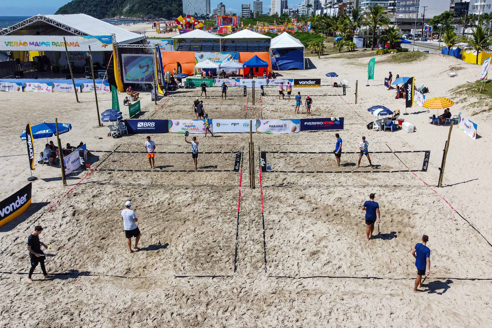 Atletas competindo no Desafio de Beach Tennis na Praia Brava, com Dagoberto como atração especial.