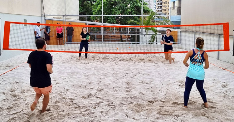 Arena Aldeia, espaço dedicado ao beach tennis no Méier, Rio de Janeiro, com quadras de areia e jogadores em ação.