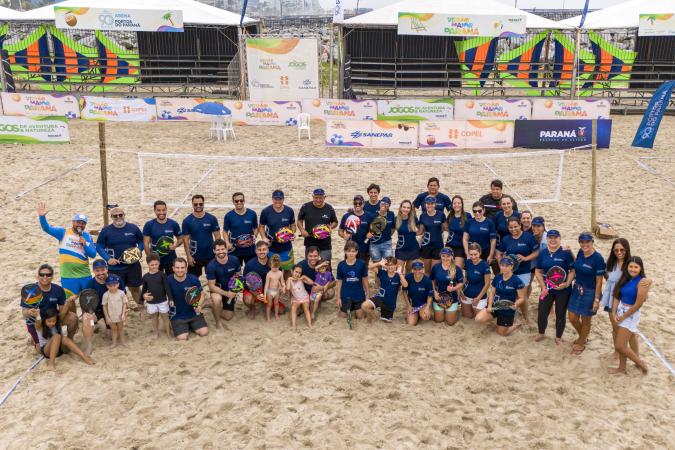 Atletas Mirella, Gustavo e Russo celebrando vitória no 1° Torneio de Beach Tennis da Portos do Paraná.