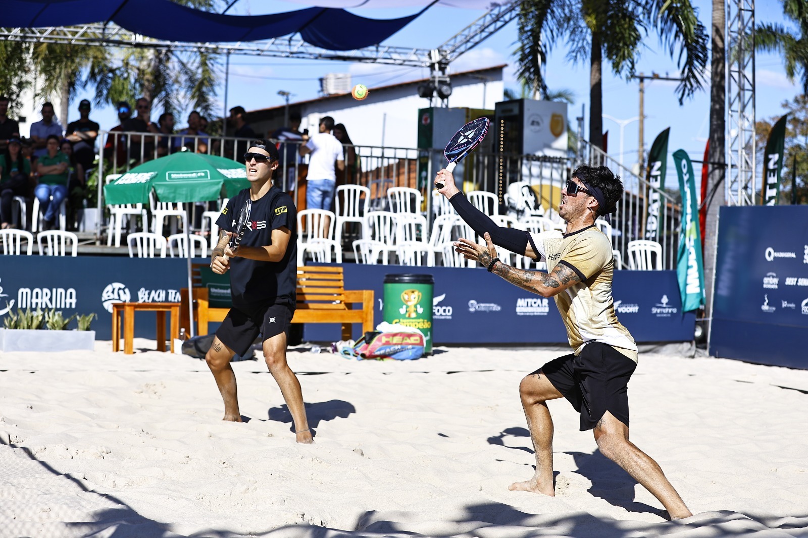 Atletas competindo no Circuito Goiano de Beach Tennis em quadra de areia.