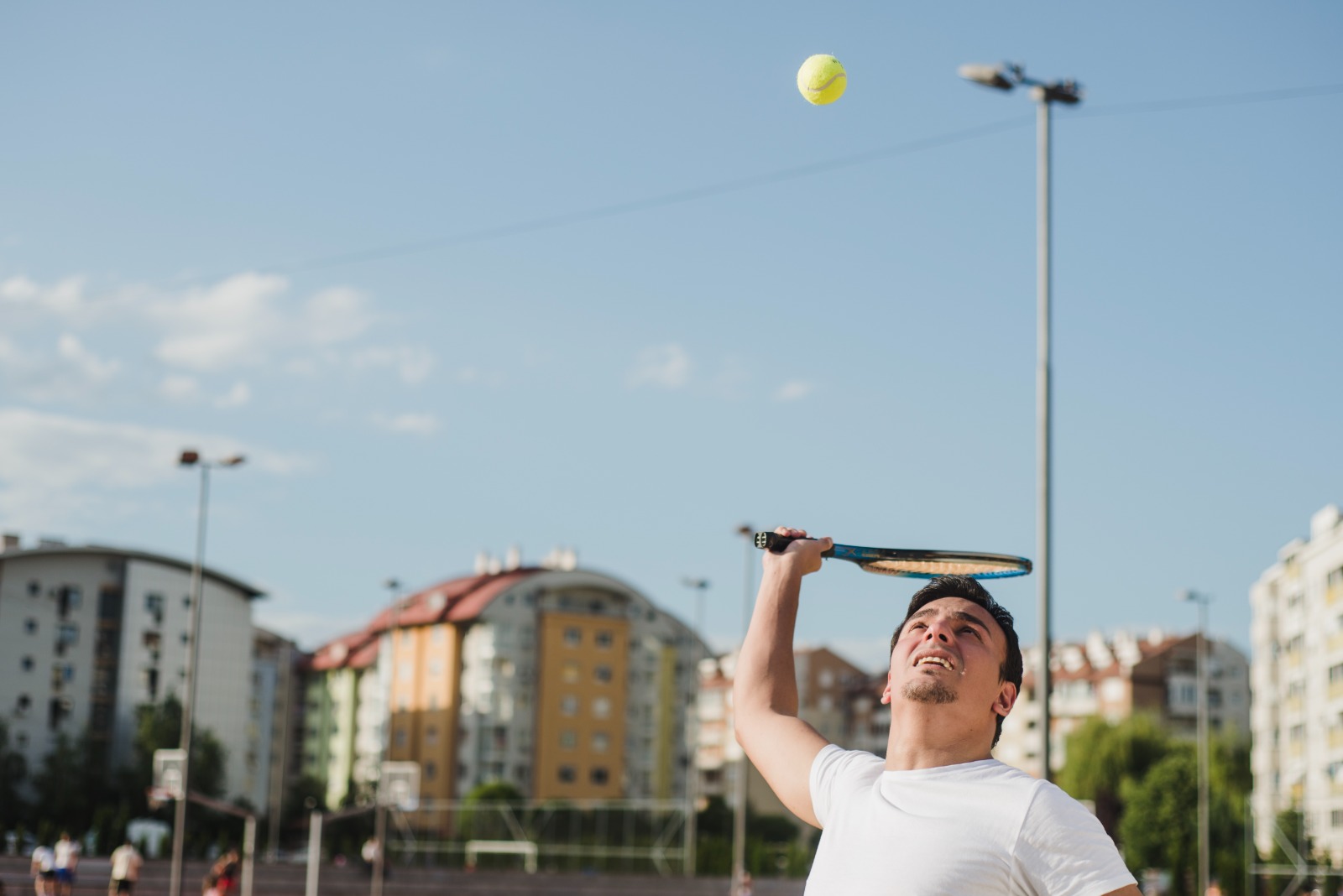 Jogadores de beach tennis em uma quadra de areia, praticando técnicas seguras para evitar lesões.