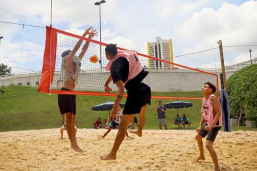 Atividades esportivas na Praia do Centro durante o Sesc Verão 2025, incluindo vôlei de praia e beach tênis.