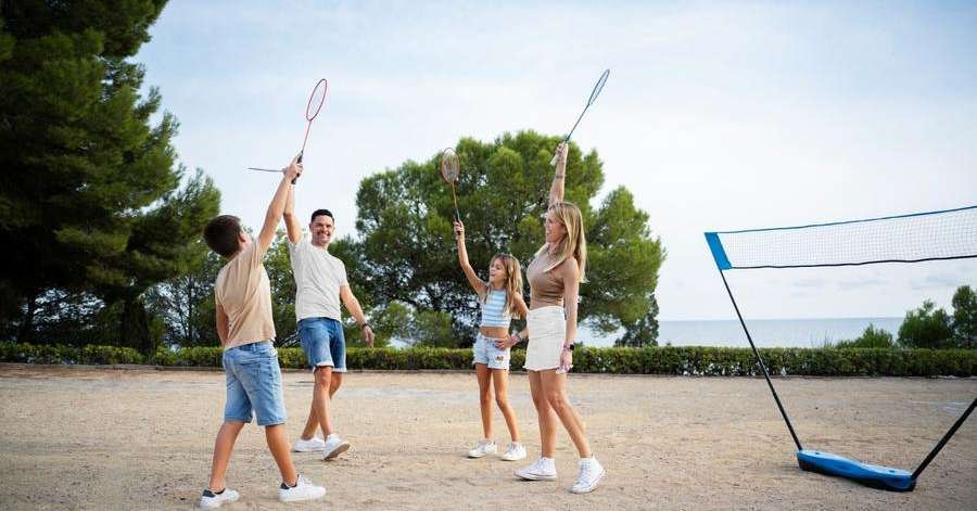 Jogadores de beach tennis se divertindo na praia durante uma partida.