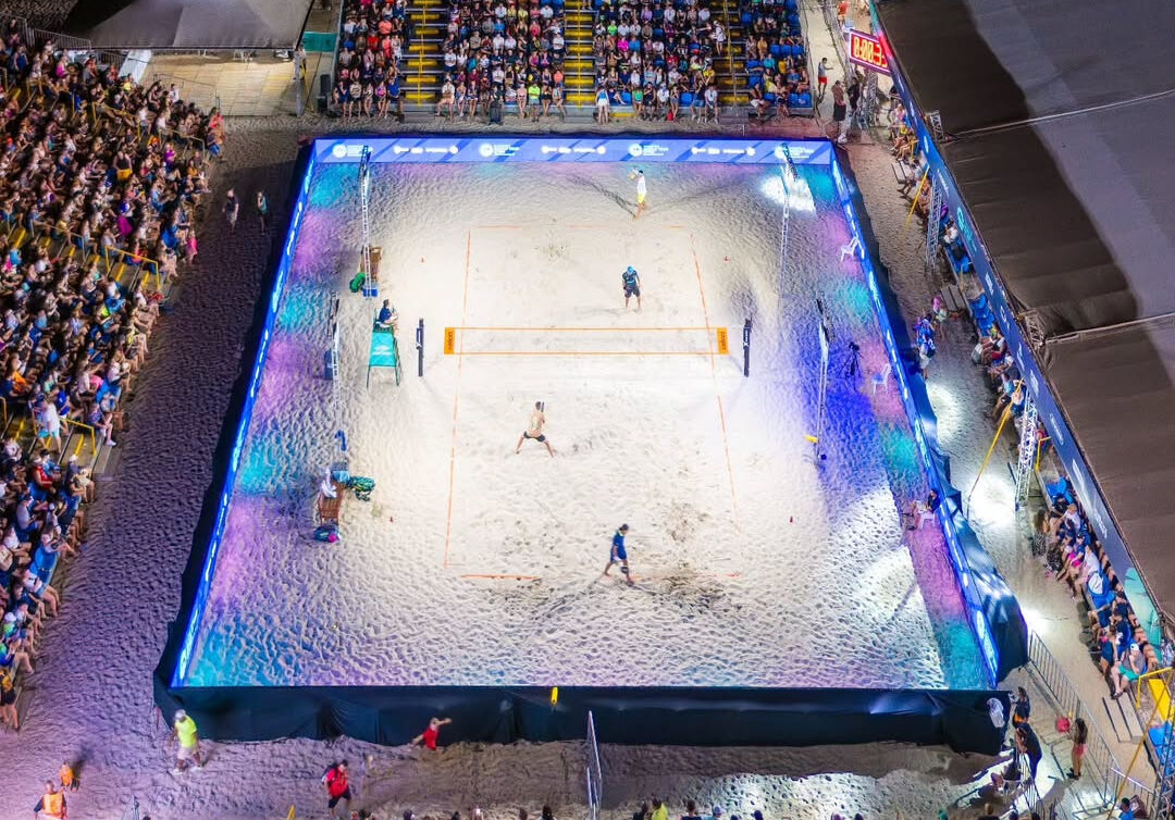 Arena do ITF BT400 Balneário Camboriú com jogadores de beach tennis em ação.