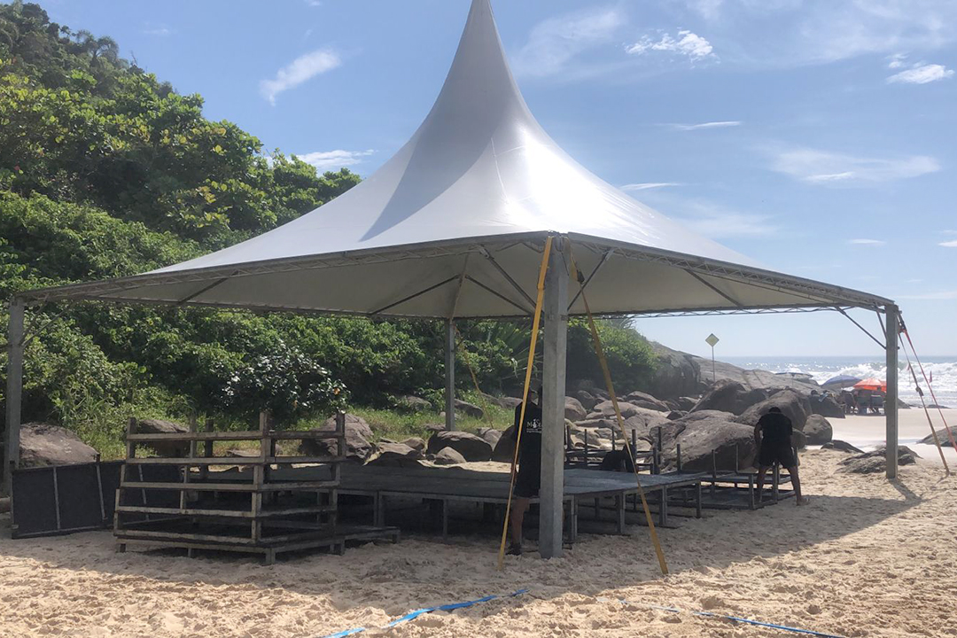 Público se divertindo no Luau na Praia do Siriú, com música ao vivo e competições de beach tennis.