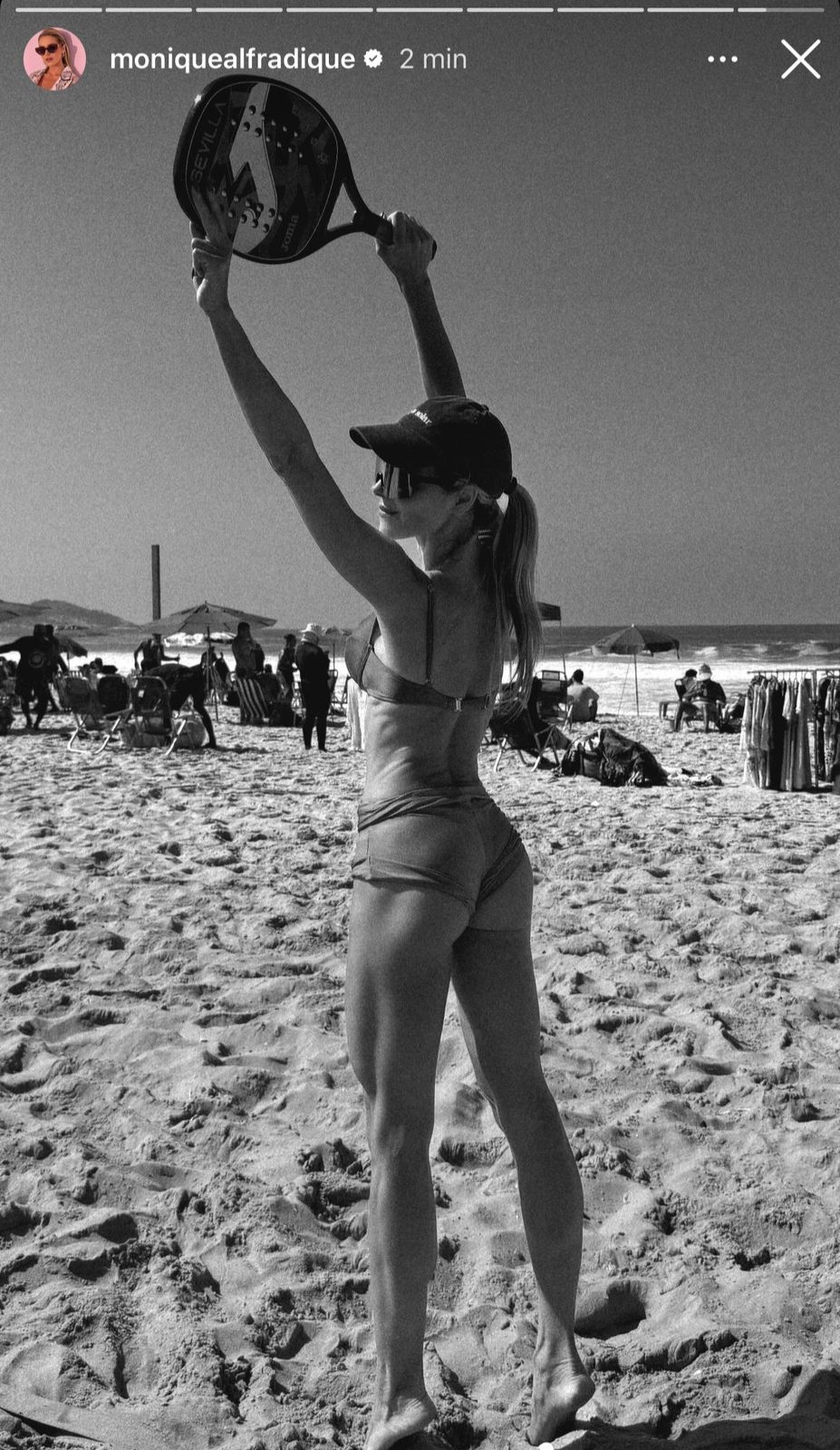 Monique Alfradique jogando beach tennis na praia, mostrando seu estilo de vida ativo e saudável.