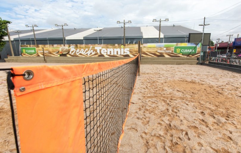 Quadras públicas de beach tennis em Cuiabá, com pessoas jogando e se divertindo na areia.