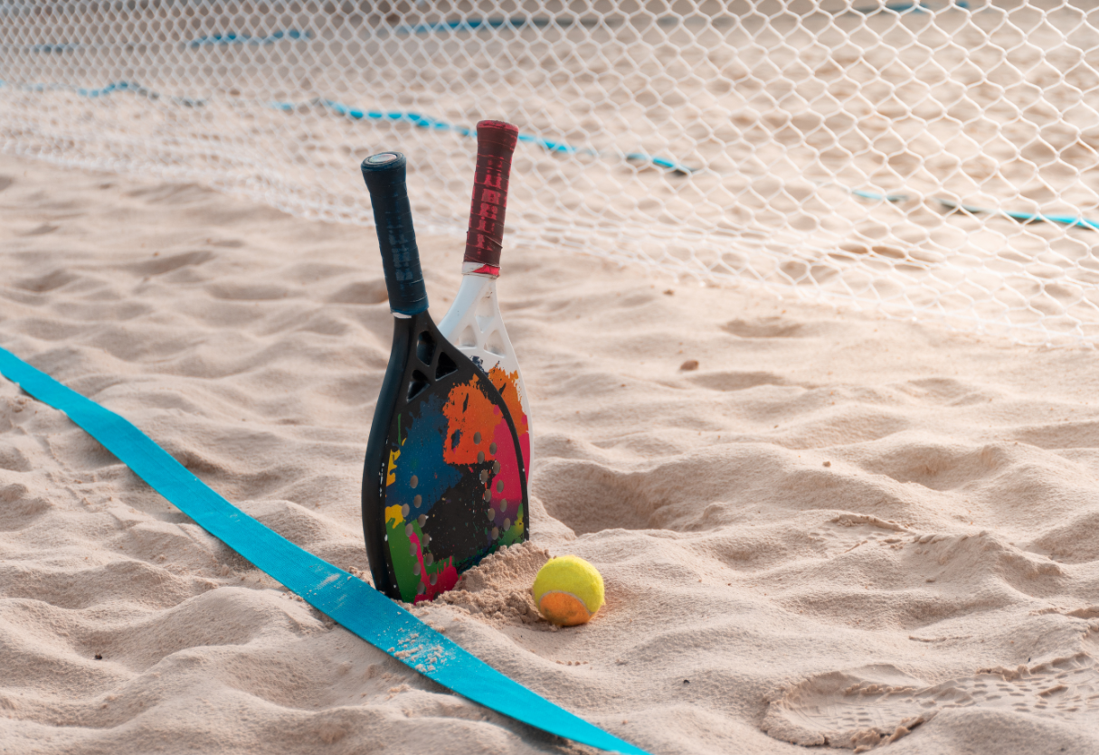Atletas competindo em uma quadra de beach tennis durante os Jogos de Verão.
