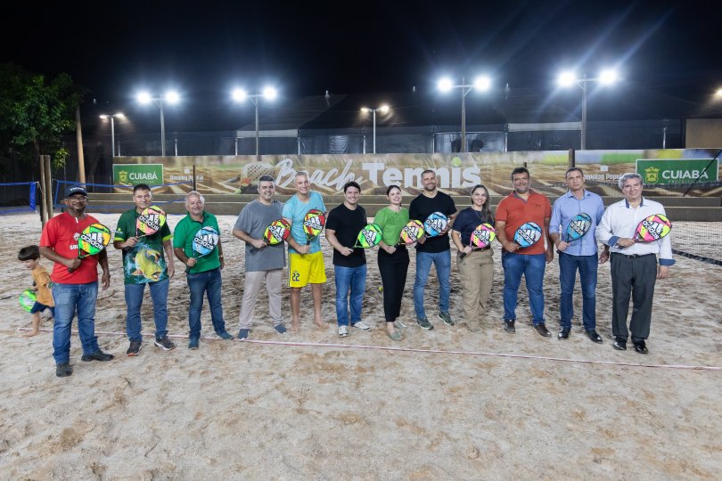 Jogadores de beach tennis se divertindo em uma quadra de areia durante uma partida.