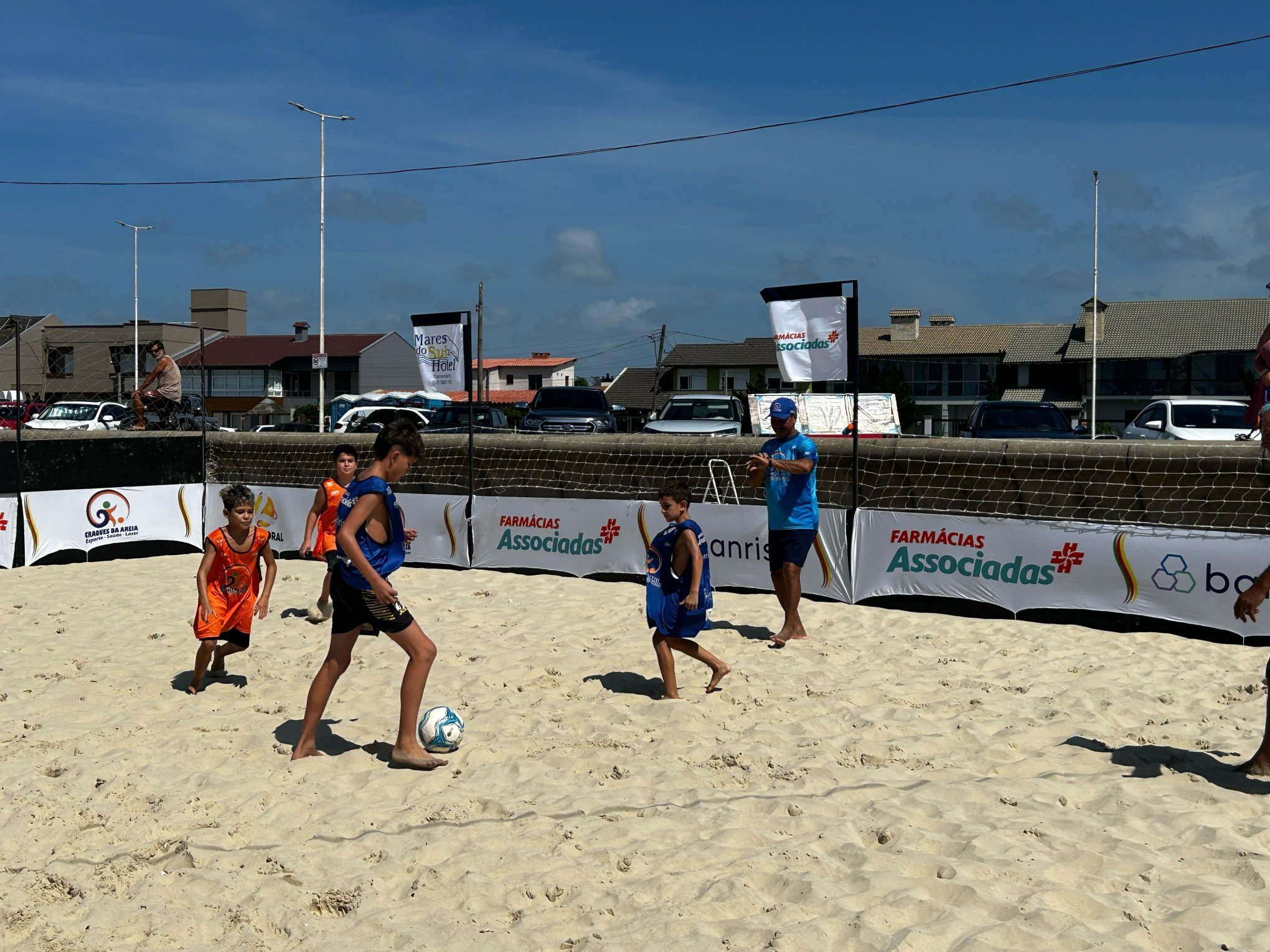 Atletas competindo em torneio de beach tennis e futebol de areia na praia de Imbé.