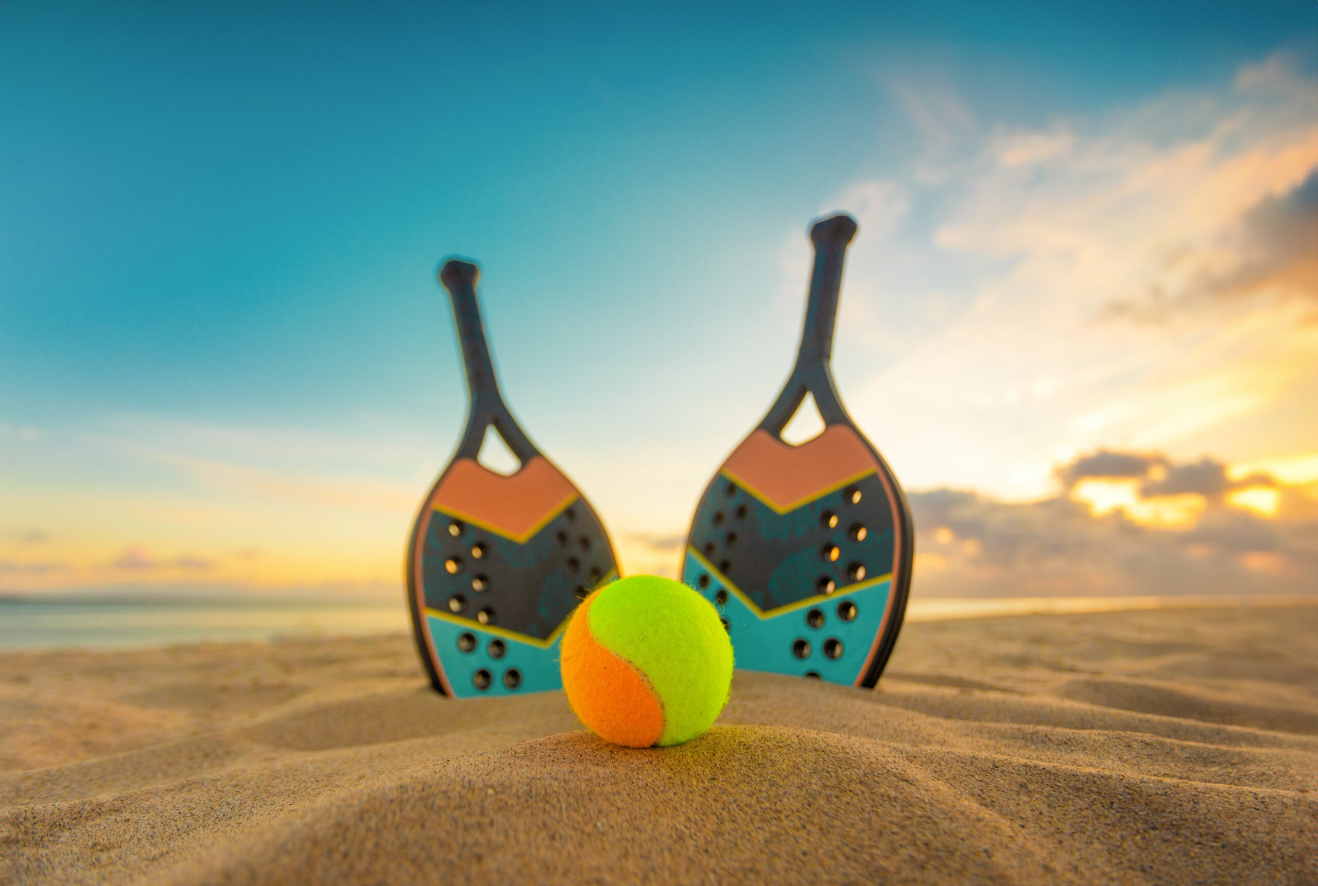 Atletas competindo no torneio de beach tennis da Smart Fit em uma quadra de areia.