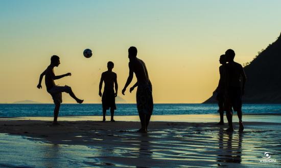 Praia de Icaraí em Niterói com pessoas praticando beach tennis e desfrutando do verão.