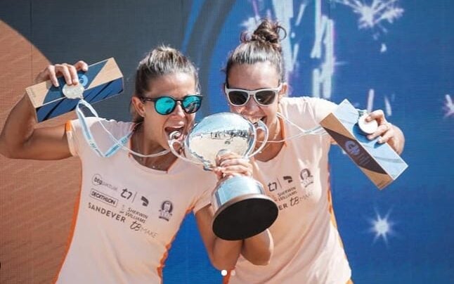 Rafaella Miiller e Patty Díaz jogando beach tennis em uma quadra de areia.
