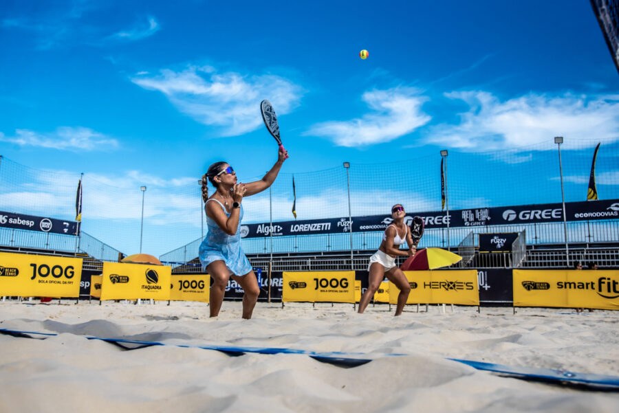 Jogadores competindo na Arena Verão+ Gree, um evento de beach tennis vibrante.