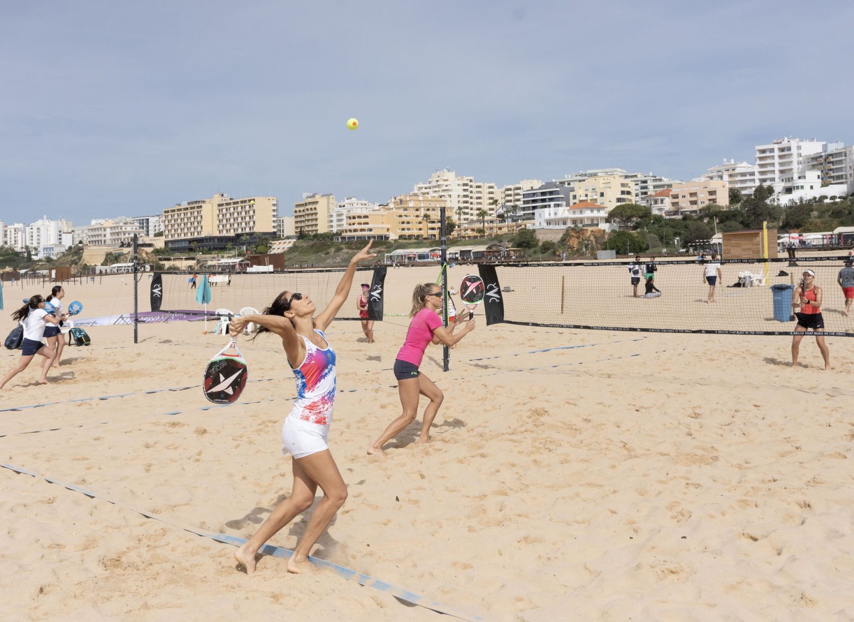 Jogadores competindo no ITF Portimão Open'25 de beach tennis na praia.