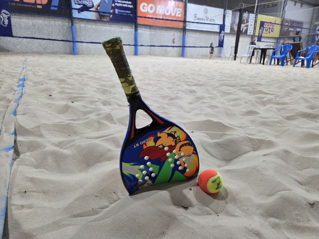 Jogadores de beach tennis se divertindo em uma quadra de areia.