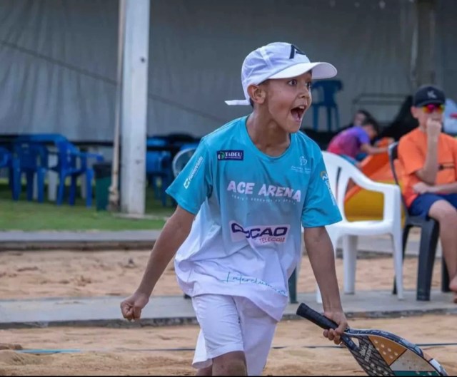 Miguel Wasem, jovem atleta de beach tennis, em ação durante uma competição na areia.