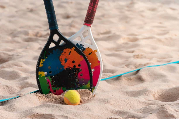 Jogadores de beach tennis competindo em um torneio solidário na praia.