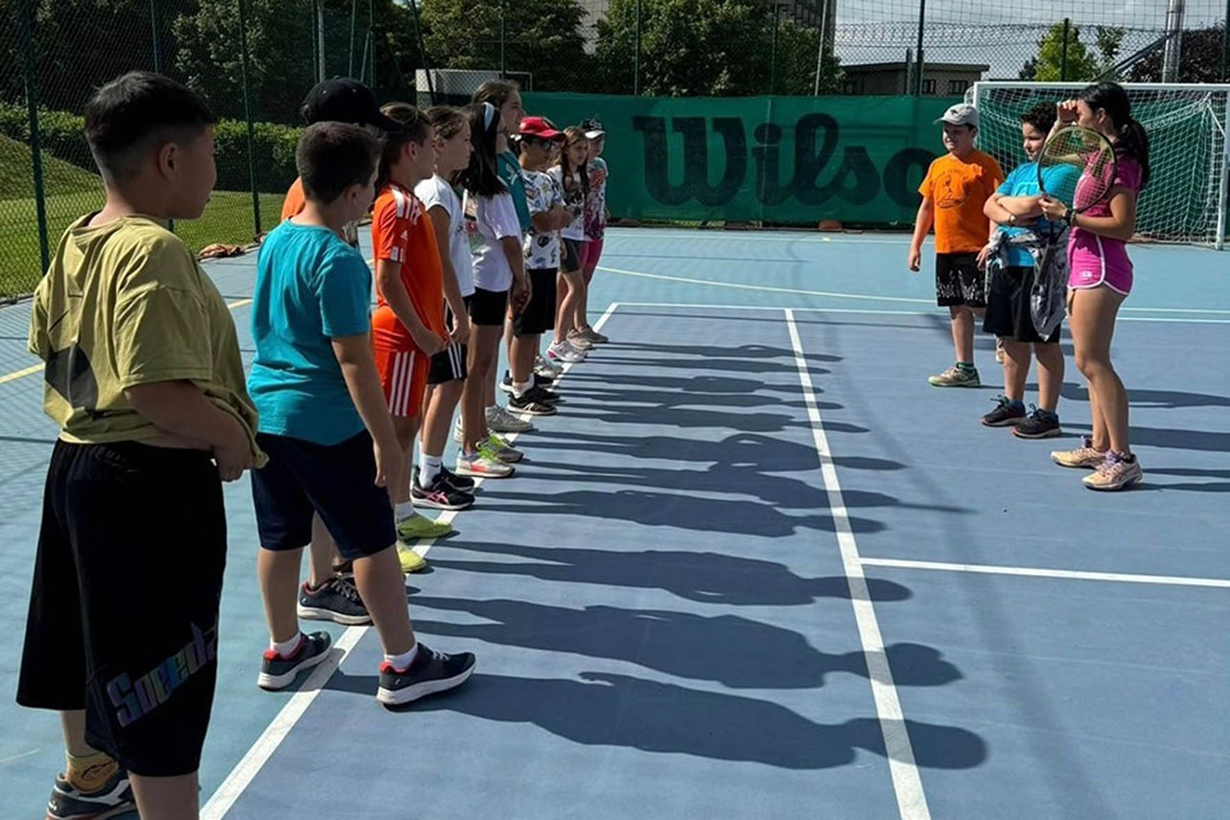 Crianças se divertindo no Valtiberina Summer Camp jogando beach tennis na praia.